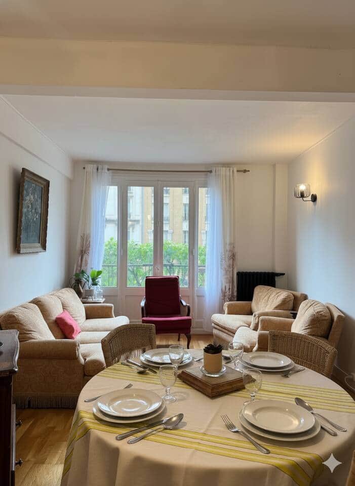 Salon lumineux ouvrant sur un petit balcon avec vue sur la rue principale de Saint-Mandé.