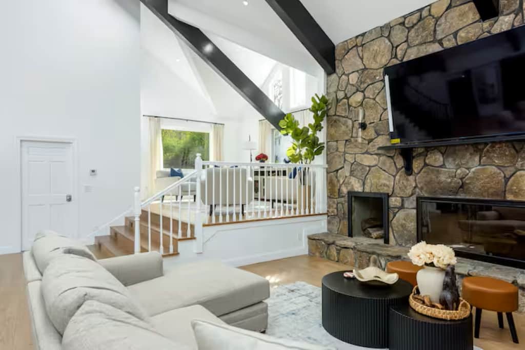 Cozy family living room with a big sectional couch, an 85-inch tv, and a fireplace (decorative only)