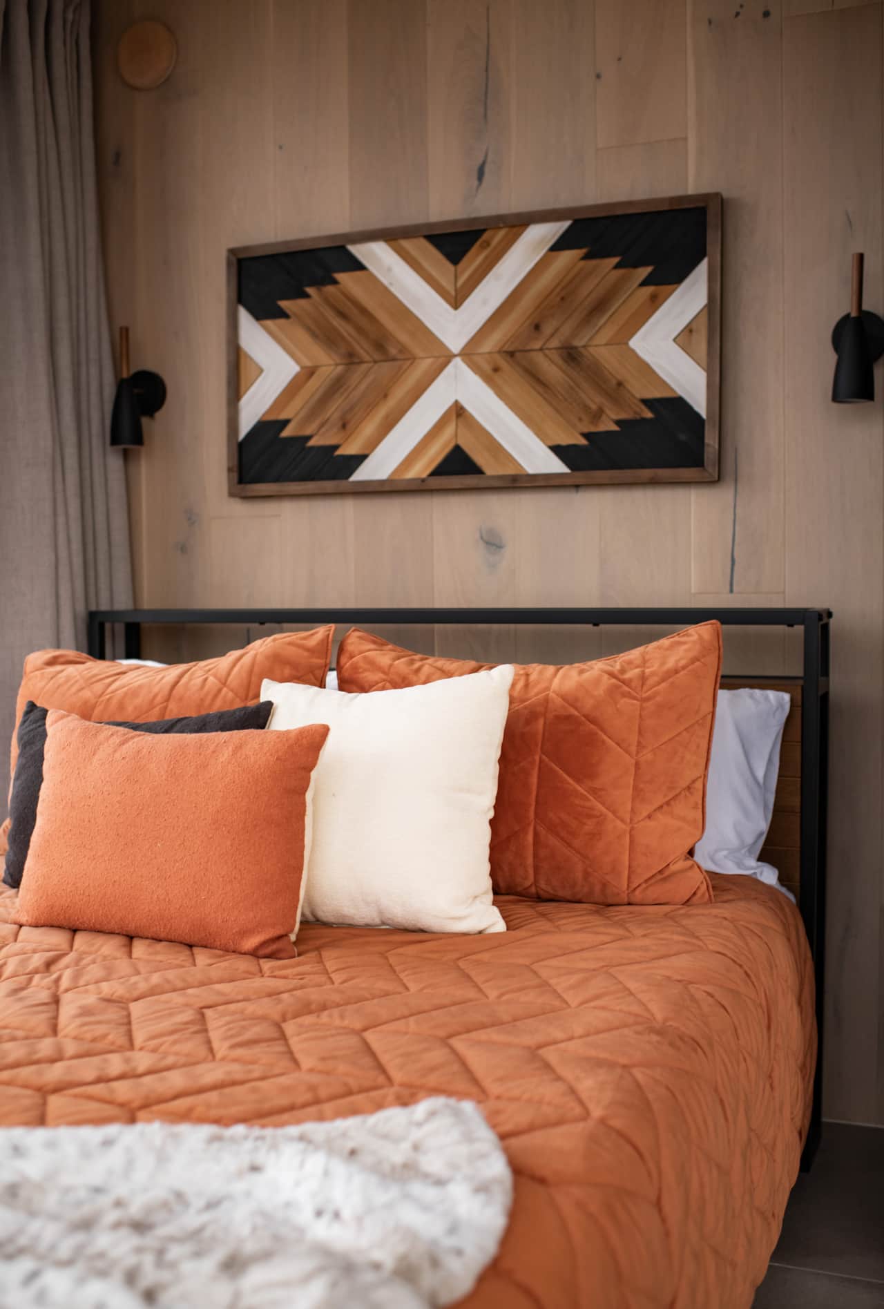 Cozy queen bed framed by glass walls with sweeping mountain views.