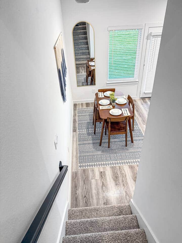 Cozy dining area with a table set for four, located just off the staircase. Perfect for casual meals, morning coffee, or planning the day in a bright, welcoming space.