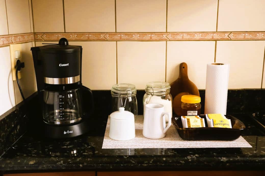 ☕ El bar de café y té ofrece cafetera, azúcar, miel, variedad de tés y opciones de café para quienes prefieren instantáneo o cafe batido, listo para disfrutar a tu manera.