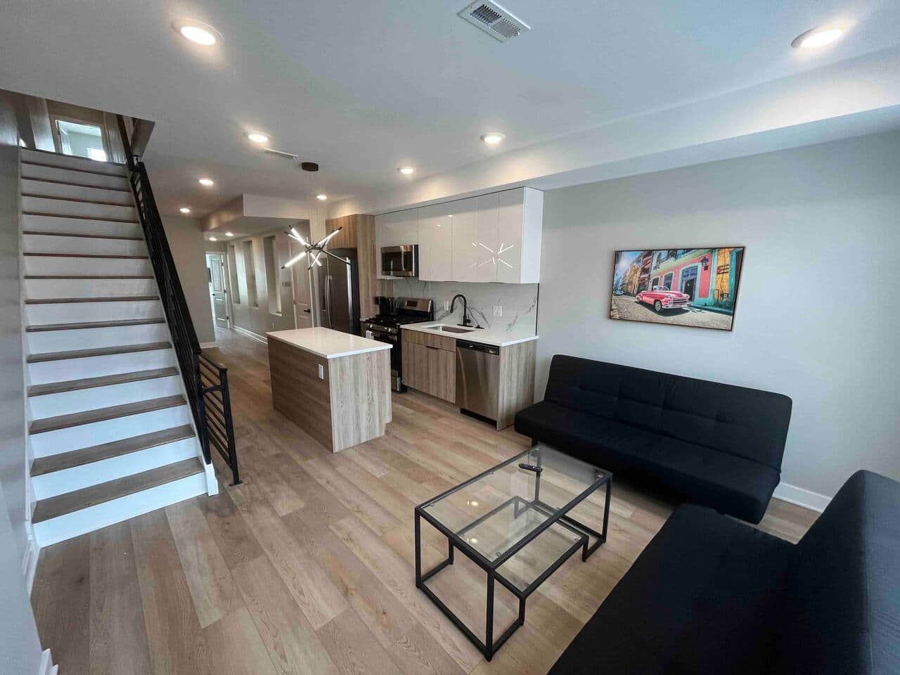 Relax in the inviting living room, equipped with two comfortable sofa beds, a flatscreen TV, and large windows that fill the space with beautiful natural sunlight. The room seamlessly connects to a modern kitchen featuring a convenient breakfast bar.
