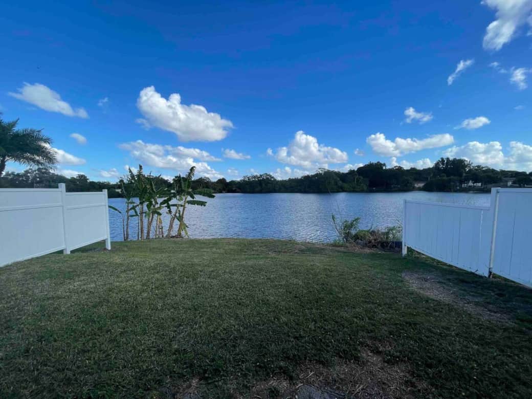Peaceful lake view with privacy fencing on both sides for a quiet, secluded stay.