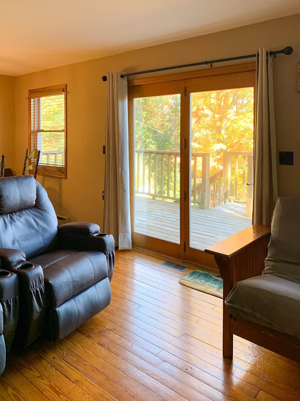 Living Room Retreat: Relax on plush seating with vibrant autumn views through glass doors!
