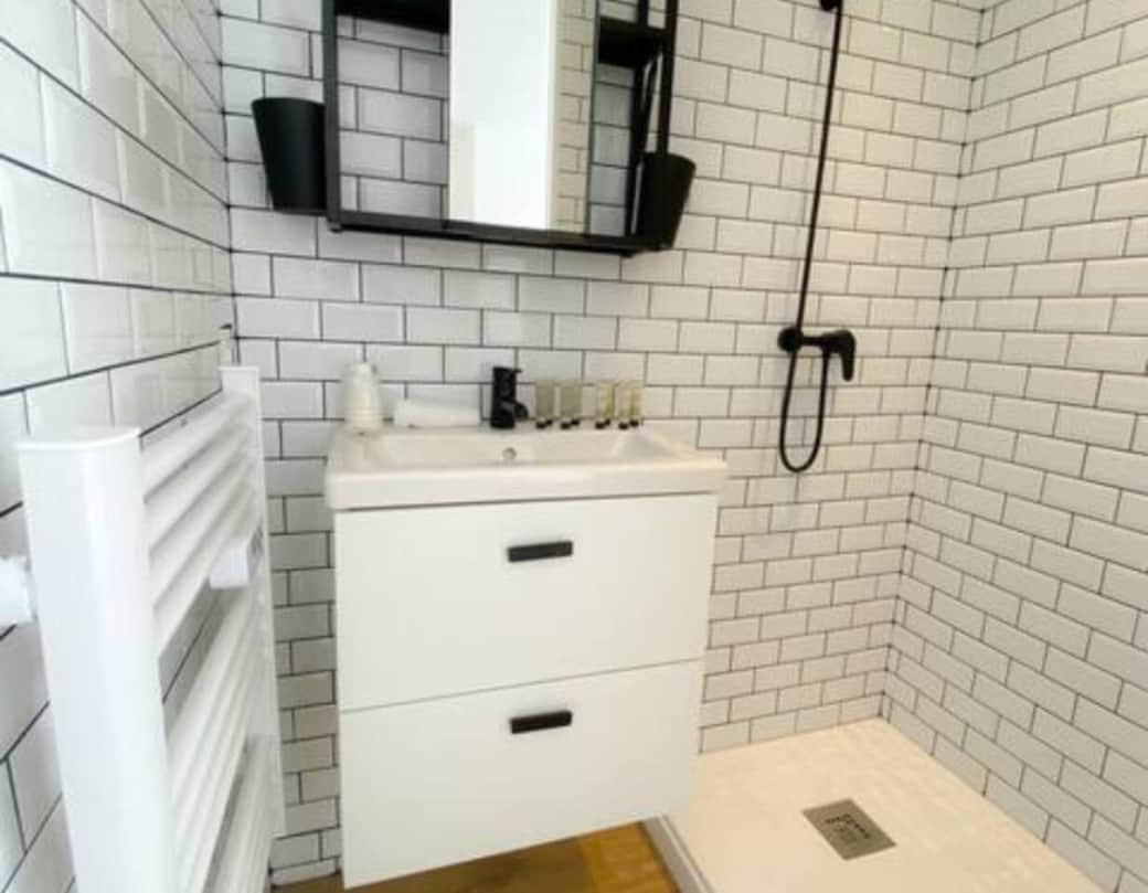 Salle de bain moderne avec douche, serviettes propres et articles essentiels