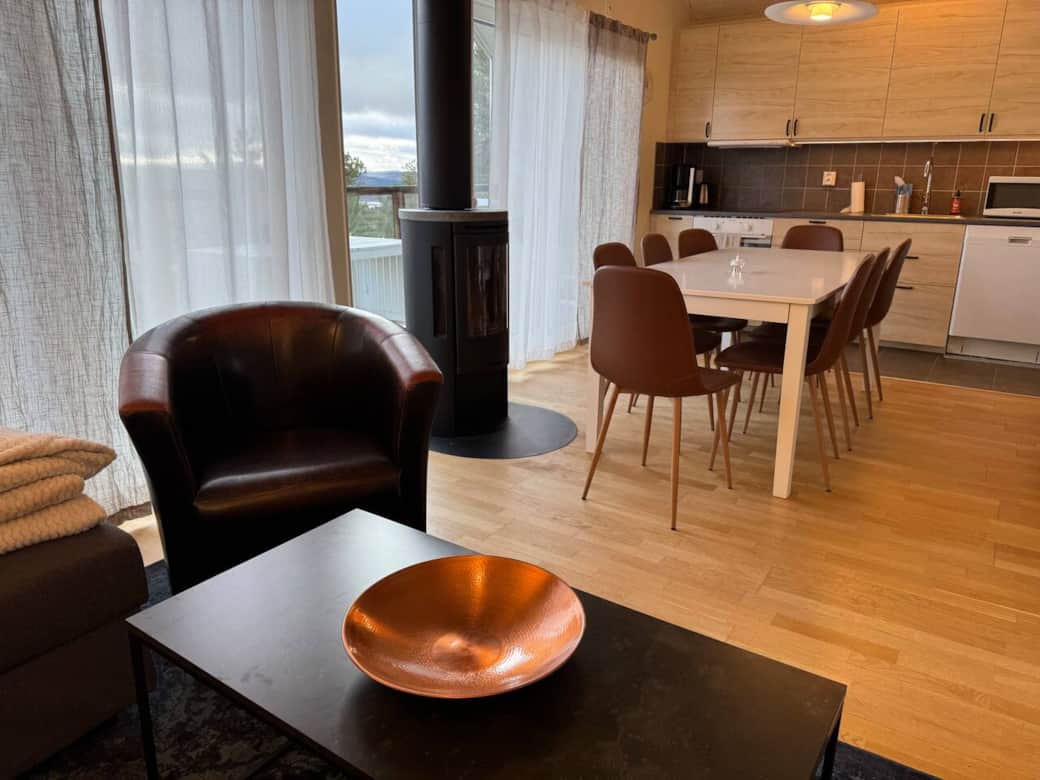 Matplats och vardagsrum med stora fönster mot balkongen och utsikt över dalgången.