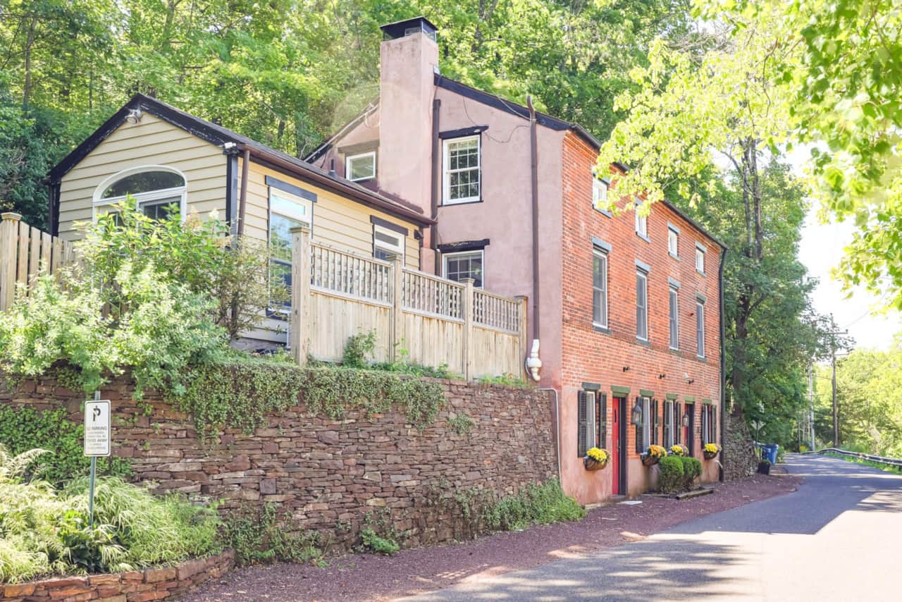 The brick façade of John Quigley House beside its stone garden wall