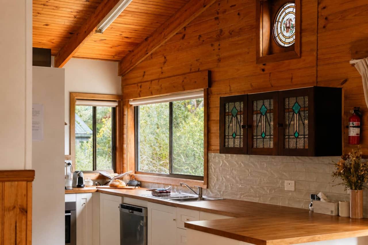 A compact, well-equipped kitchen with full-size fridge, oven, cooktop, microwave, dishwasher and plenty of bench space.