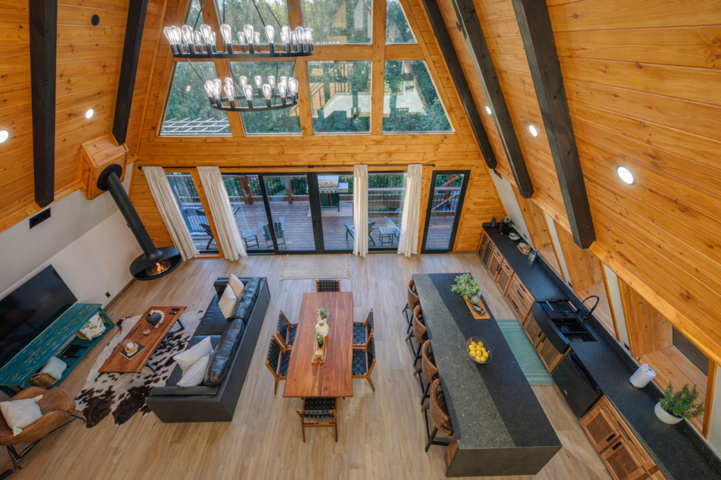 Big windows, hanging trumpet fireplace, open plan, chandelier—relax or entertain.