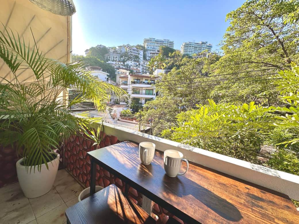 Private balcony with lush hillside views—perfect for morning coffee or a slow sunset unwind. A quiet perch above the neighborhood, surrounded by greenery and warm light.