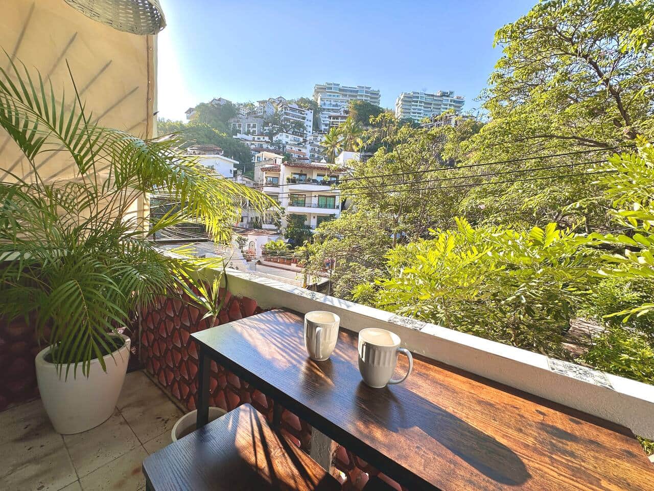 Private balcony with lush hillside views—perfect for morning coffee or a slow sunset unwind. A quiet perch above the neighborhood, surrounded by greenery and warm light.
