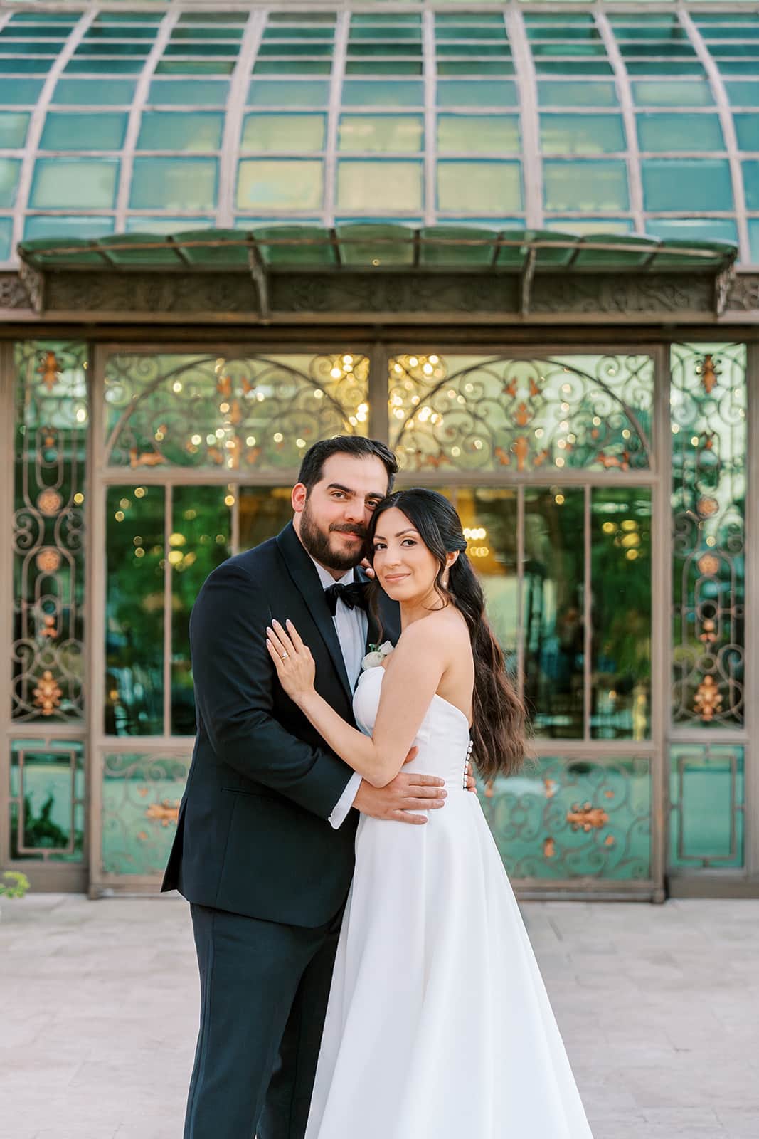 Bride and groom in an embrace outside the Bryan Museum atrium in Galveston, Texas