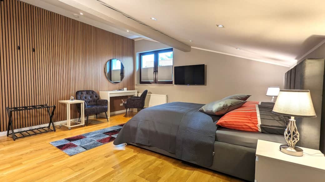 Großes, modernes Zimmer mit Doppelbett, Sitzbereich und stilvoller Ausstattung in ruhiger Lage