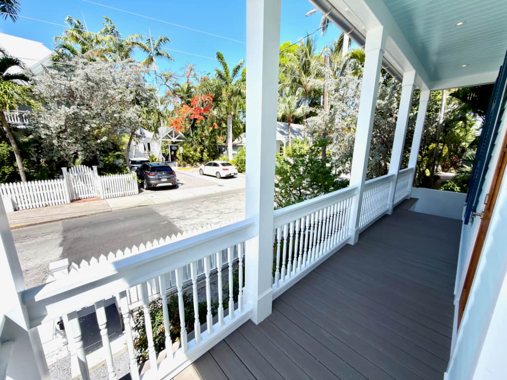 Classic Old Town Key West exterior with wraparound porches, tropical landscaping, and gated parking