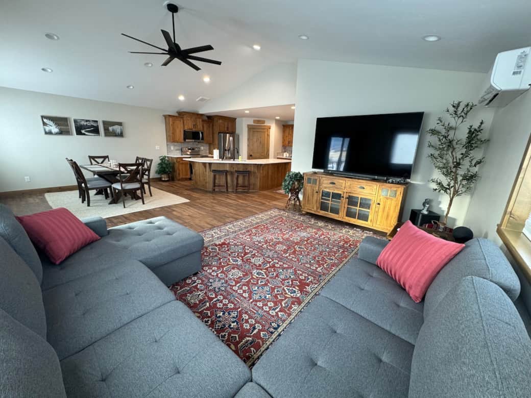 Spacious open living room with sectional and 80inch HDTV with streaming capabilities