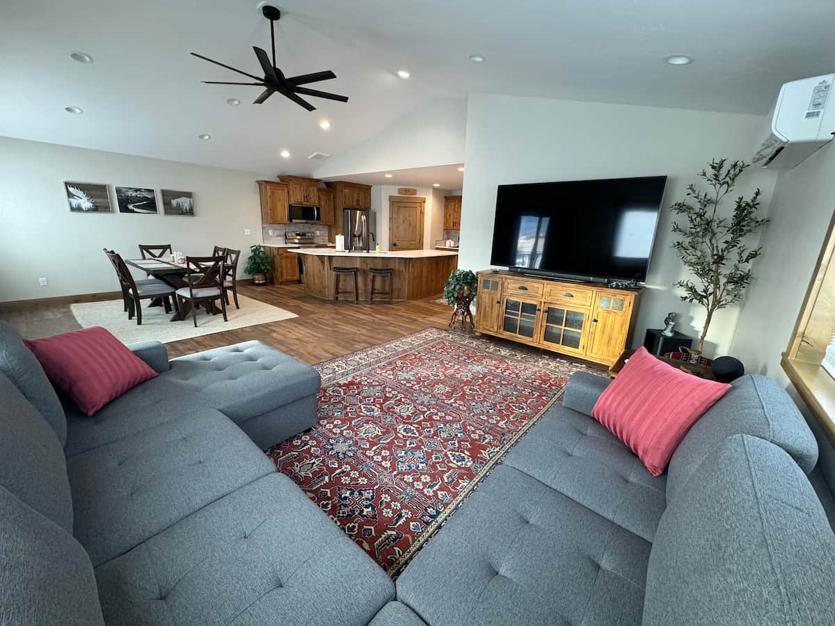 Spacious open living room with sectional and 80inch HDTV with streaming capabilities