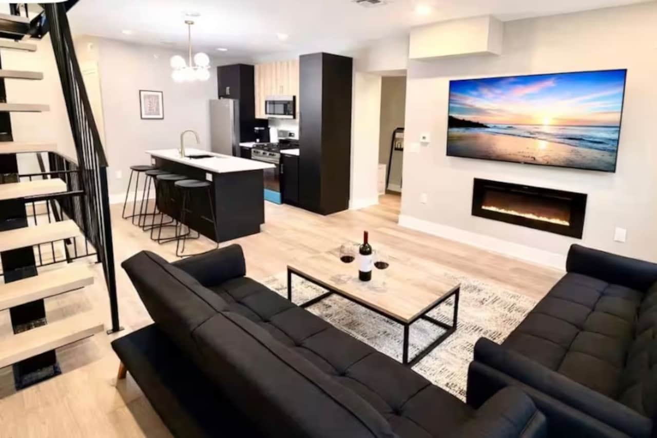 living room with two futon sofa beds, large flatscreen TV, fireplace, and Steps to go to the Roof top.