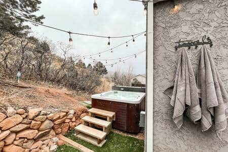 Private hot tub with string lights and sitting area.