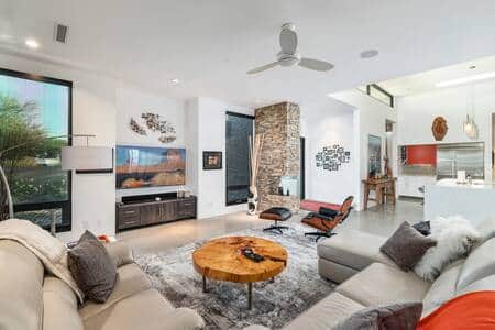 Family room with custom artwork all around, smart TV, cozy leather couches