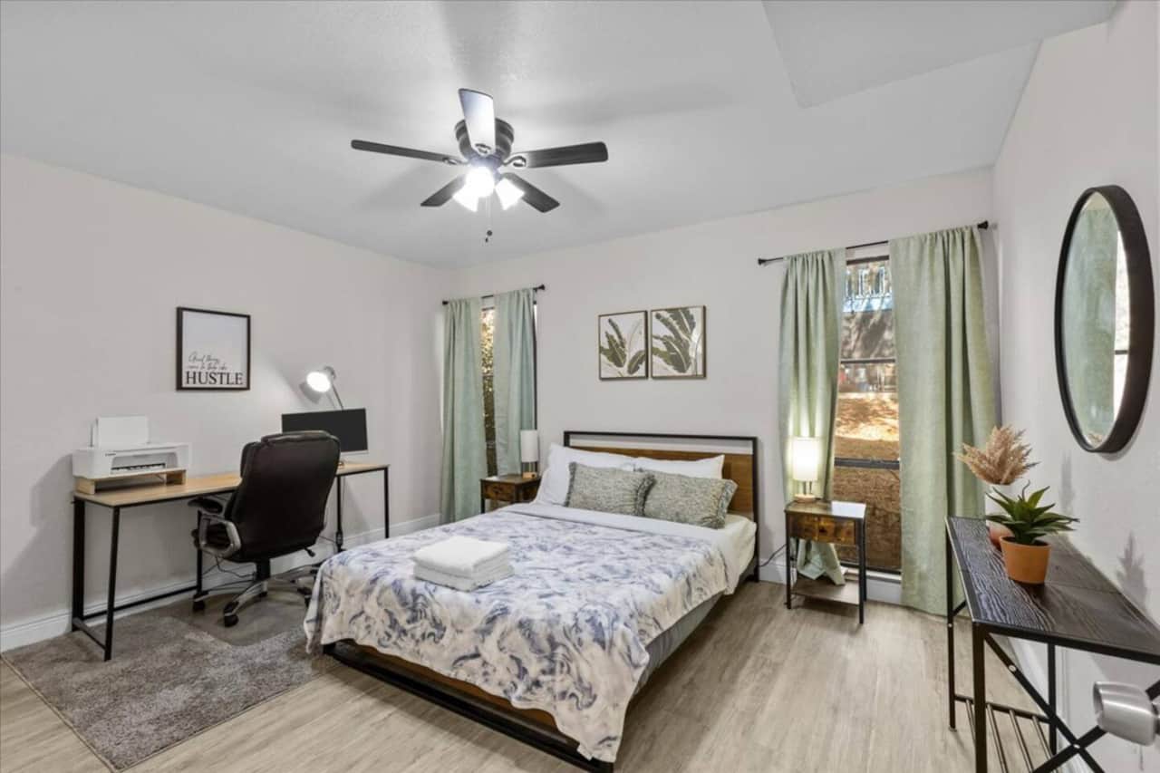 Bedroom with Queen Bed, office desk and chair. Closet in front of bed.