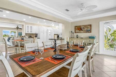 Dining area is bathed in natural light. The rear entrance offers balcony access