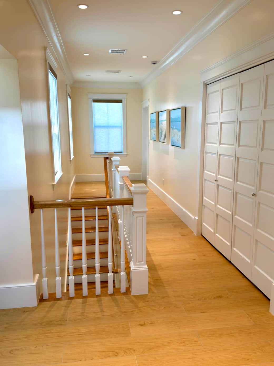 Bright upstairs hallway connecting the bedrooms, laundry area, and convenient wet bar.