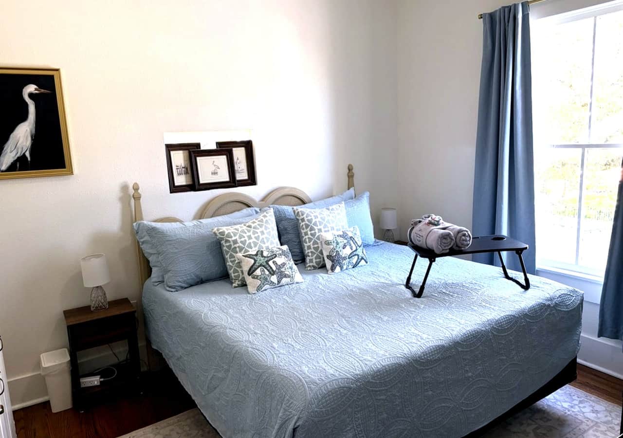 Cozy king bedroom at White Magnolia Galveston with TV and blackout curtains