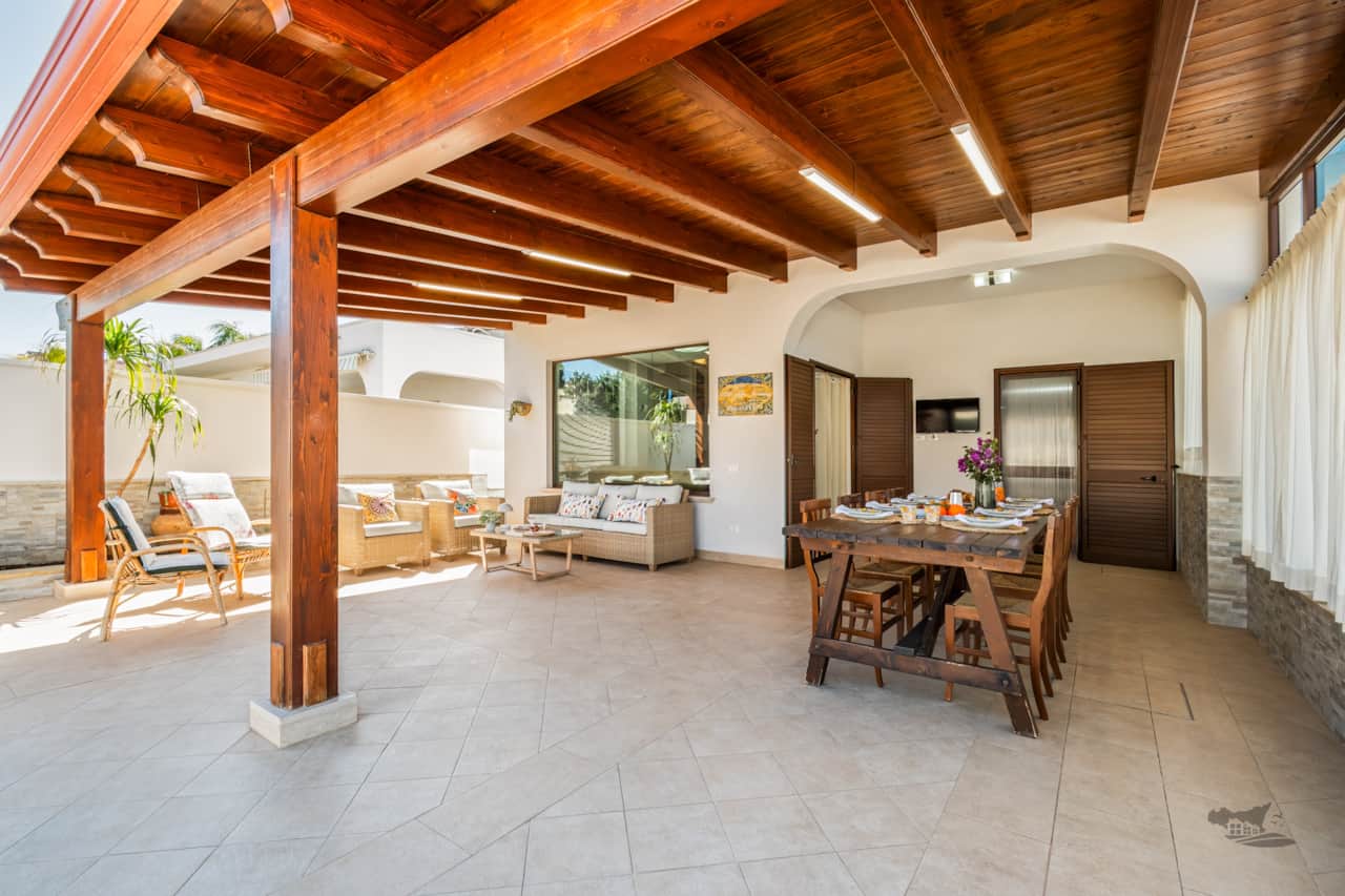 Inviting patio with cozy seating and a spacious wooden table for outdoor meals.