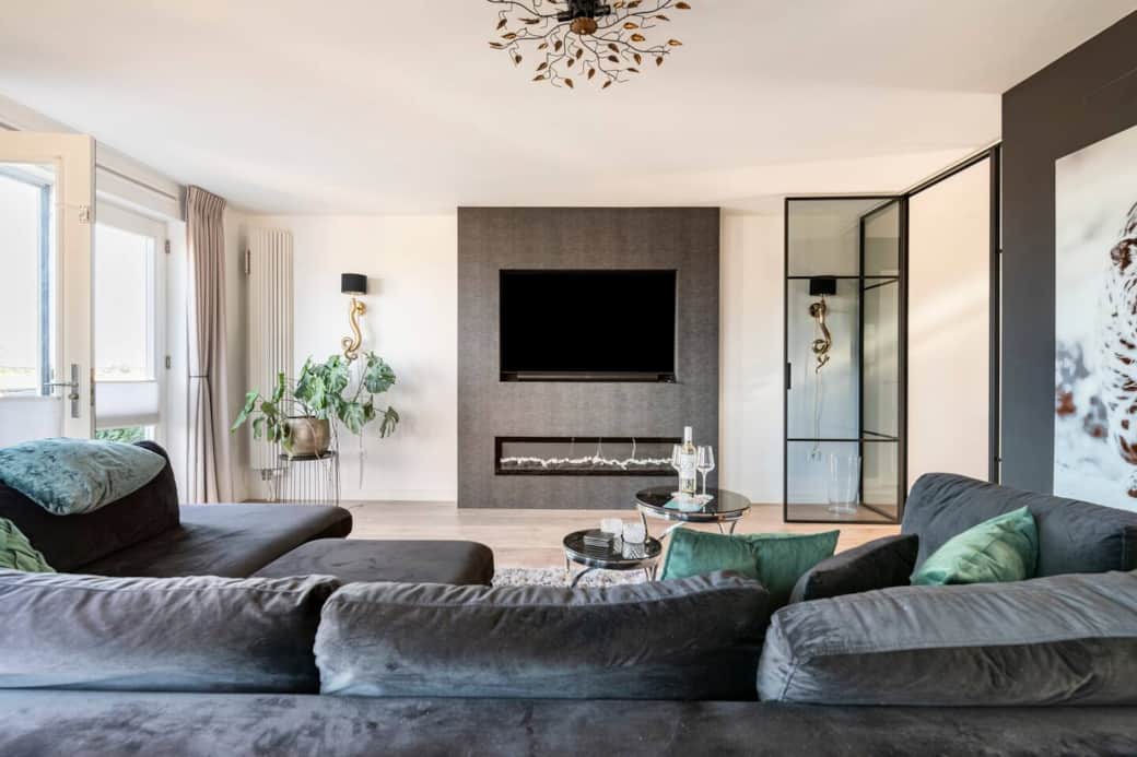 Living room equipped with a large seating area, electric fireplace, and multimedia facilities