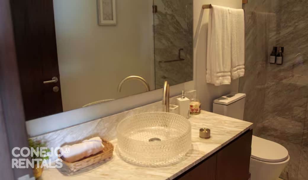 Baño elegante con acabados de lujo y grifería dorada en Bolongo Punta de Mita Baño elegante con acabados de lujo y grifería dorada en Bolongo Punta de Mita