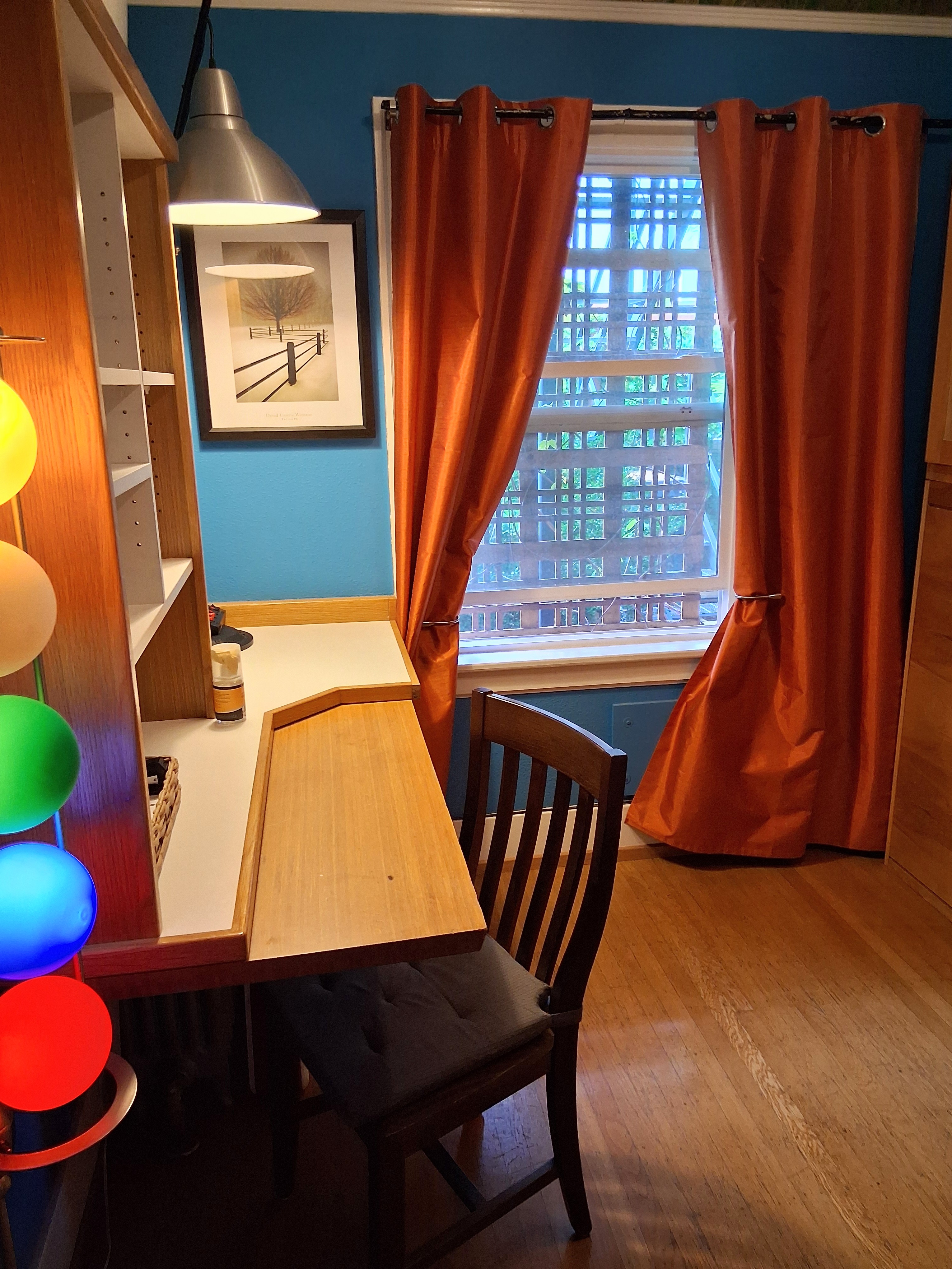 The second bedroom offers a murphy bed, workspace, large window, closet space and more lamps.