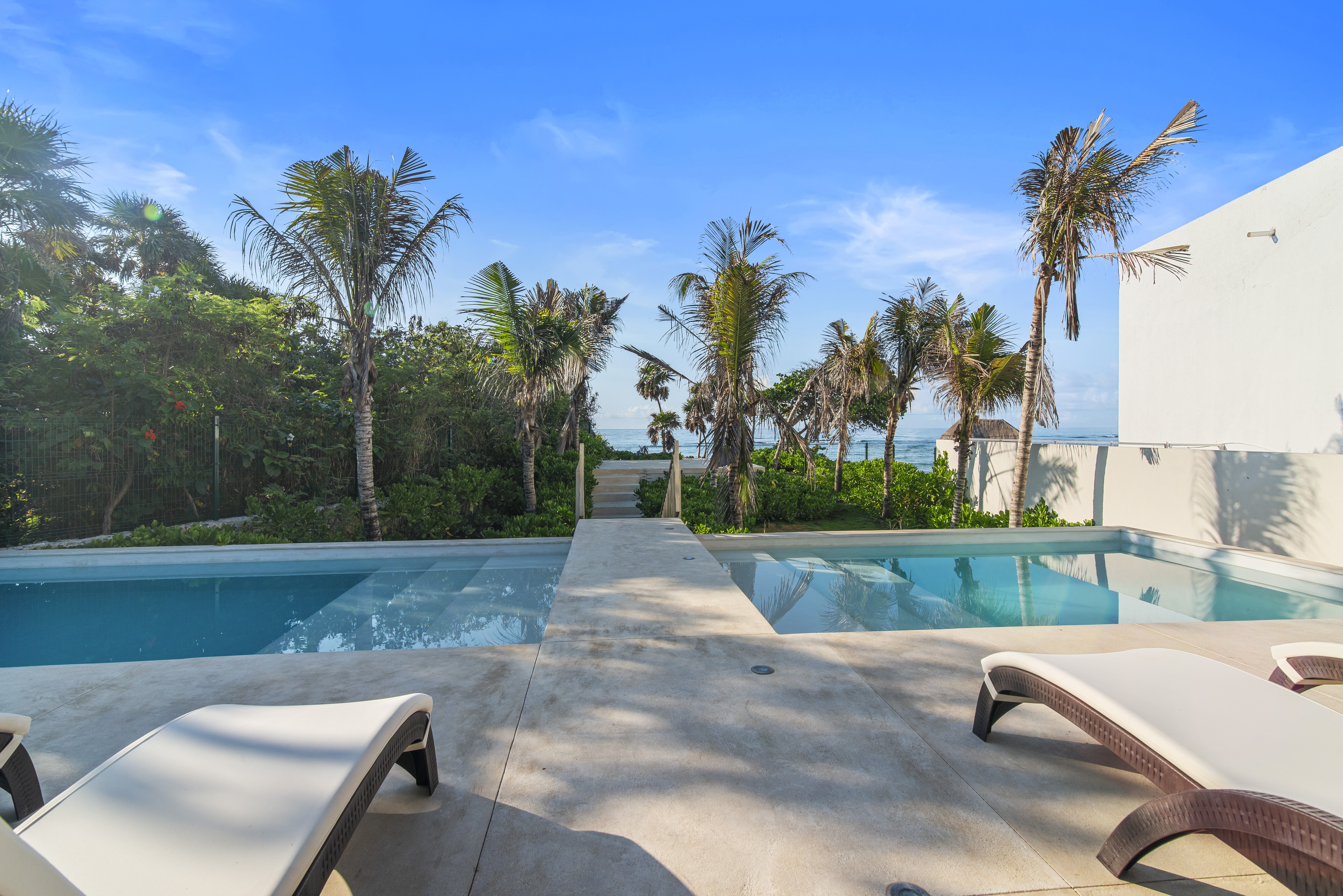 Enjoy exclusive beach club access with pools, shaded loungers, and direct access to the beach.