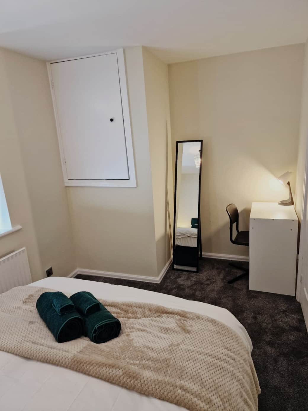 Bedroom with dedicated workspace and full-length mirror.