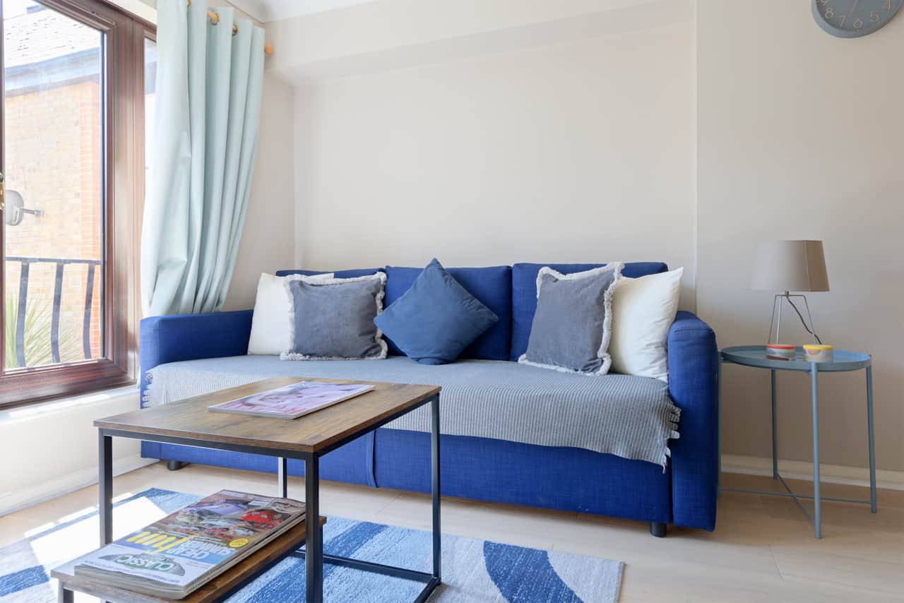 Blue sofa bed styled with an assortment of scatter cushions