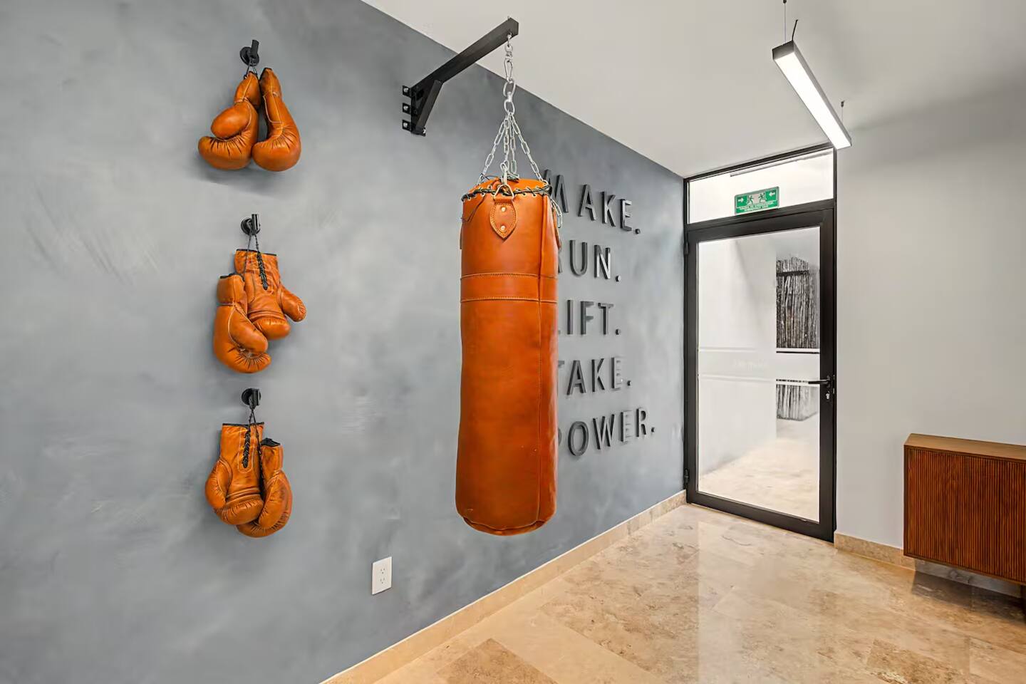 El gimnasio cuenta con costal de box con guantes y también incluye caminadoras, 2 bicicletas fijas, mancuernas, pesas libres, pesas rusas, balones medicinales, bancos de pesas, equipo de fuerza y máquina de poleas para un entrenamiento completo.