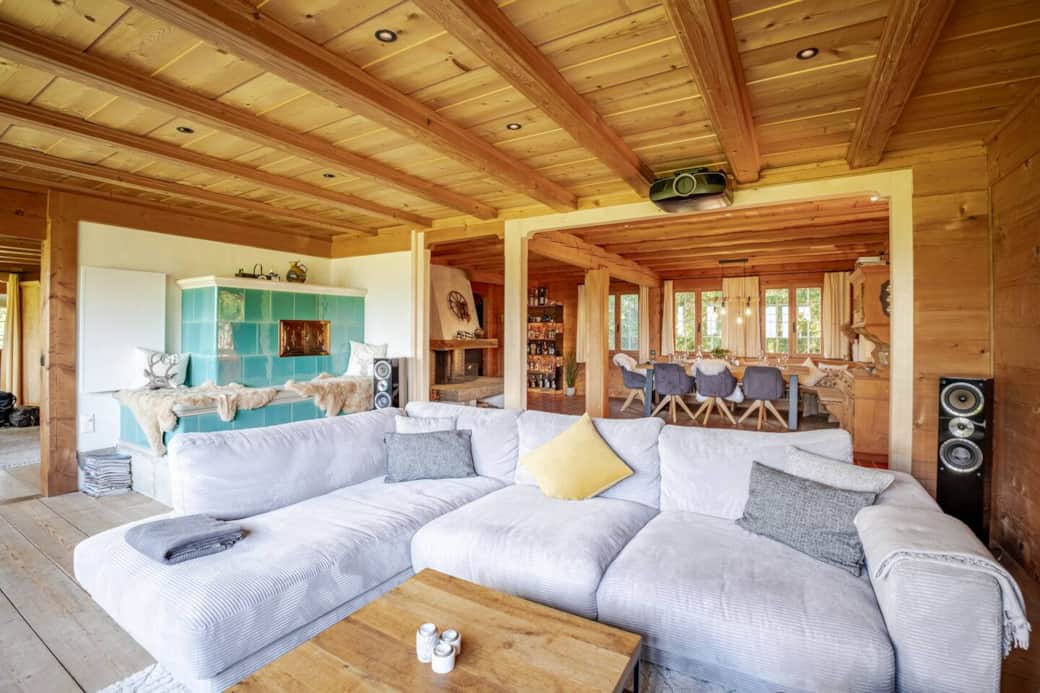 Unwind in the spacious living room, where breathtaking mountain views, a cozy tiled stove, and a state-of-the-art home theater await.