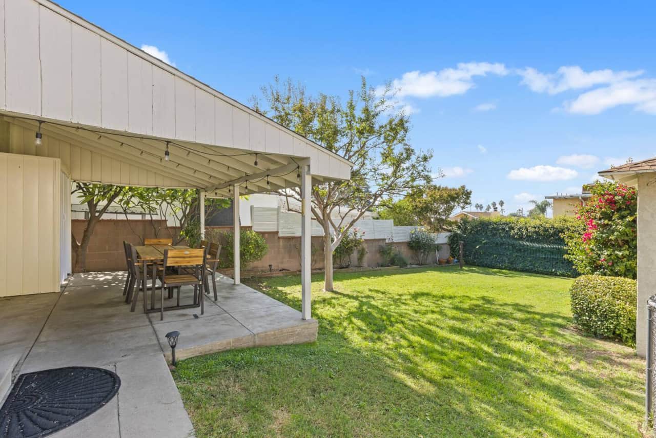 Dinner al fresco! Enjoy the covered patio with shaded seating and a lush backyard—perfect for afternoon breezes.
