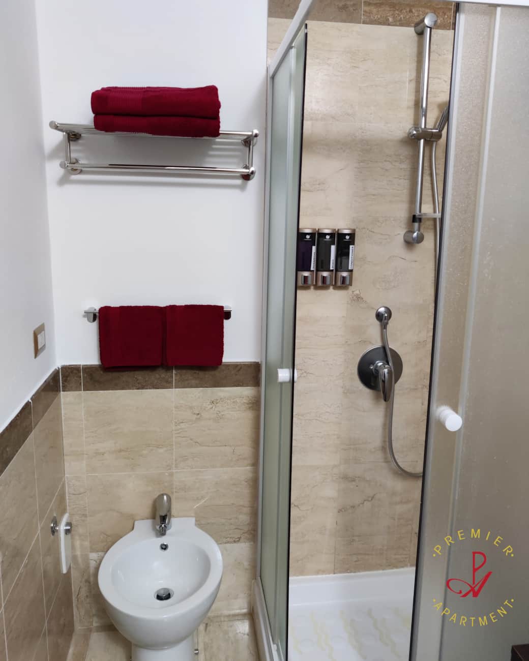 Baño con bidet y ducha con dispensadores de champú, gel de ducha y acondicionador.