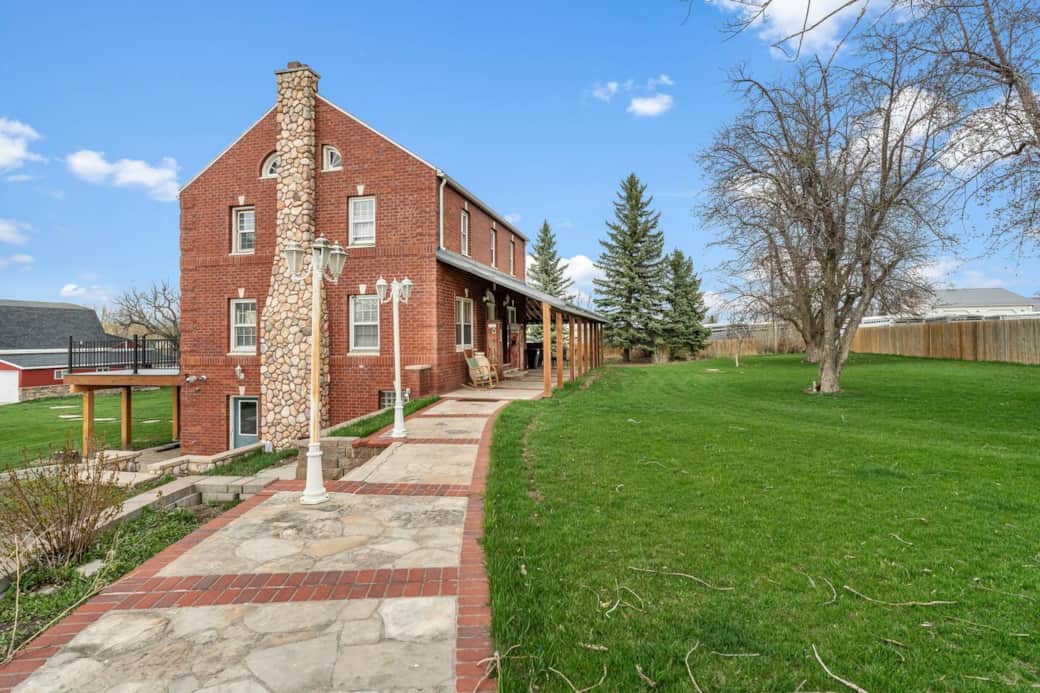 Follow the charming brick and stone walkway to the front door, flanked by vintage details and rocking chairs. To the left, you’ll find two private parking spots; to the right, a spacious front yard—partially fenced and perfect for pets to roam.