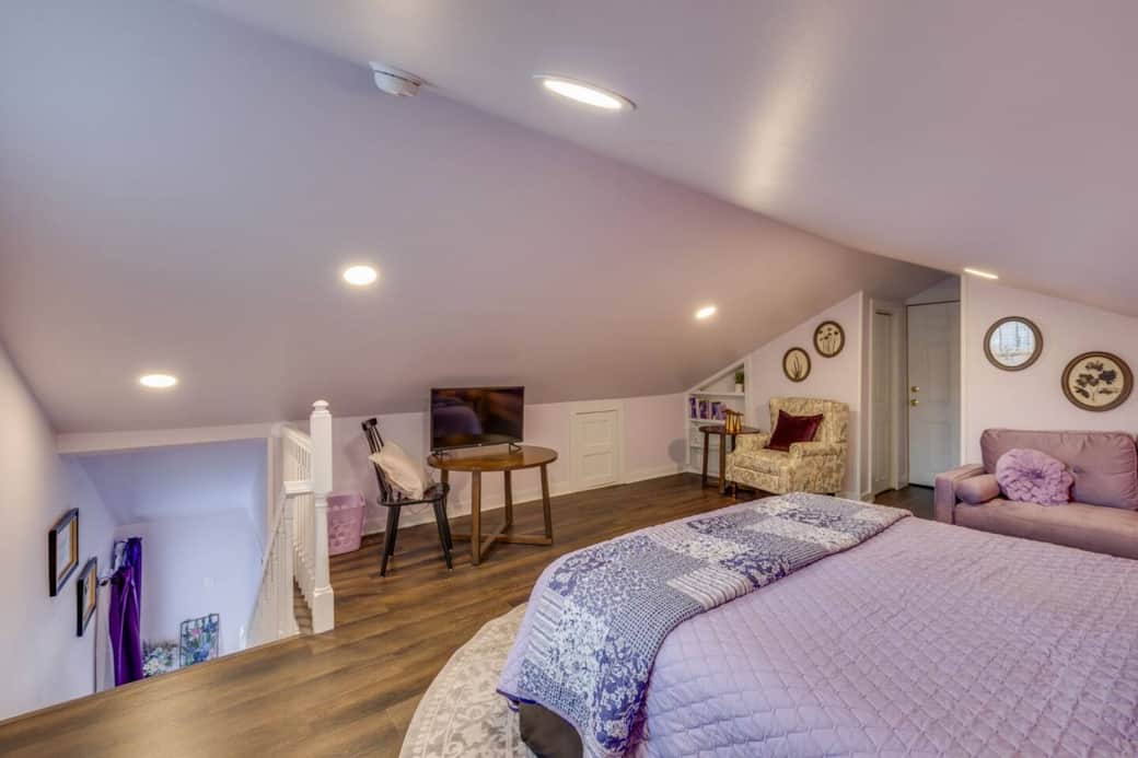 The loft includes a queen bed, smart TV, and a cozy seating area, plus a small dedicated workspace.