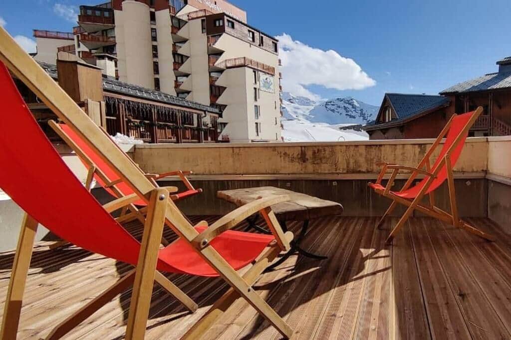 Terrasse avec transats rouges et vue montagne — Lac Blanc, Val Thorens