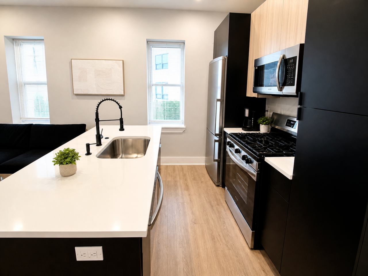 Modern fully equipped kitchen with island seating, stainless steel appliances, microwave, stove, fridge, and all essentials for cooking and dining.
