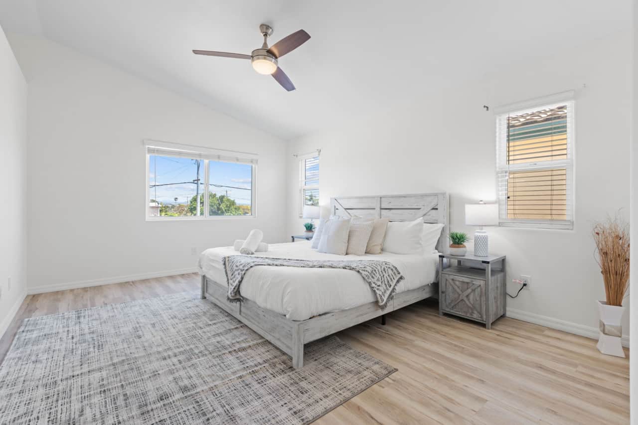 Spacious main bedroom with natural light, king bed & cozy, coastal-inspired decor.