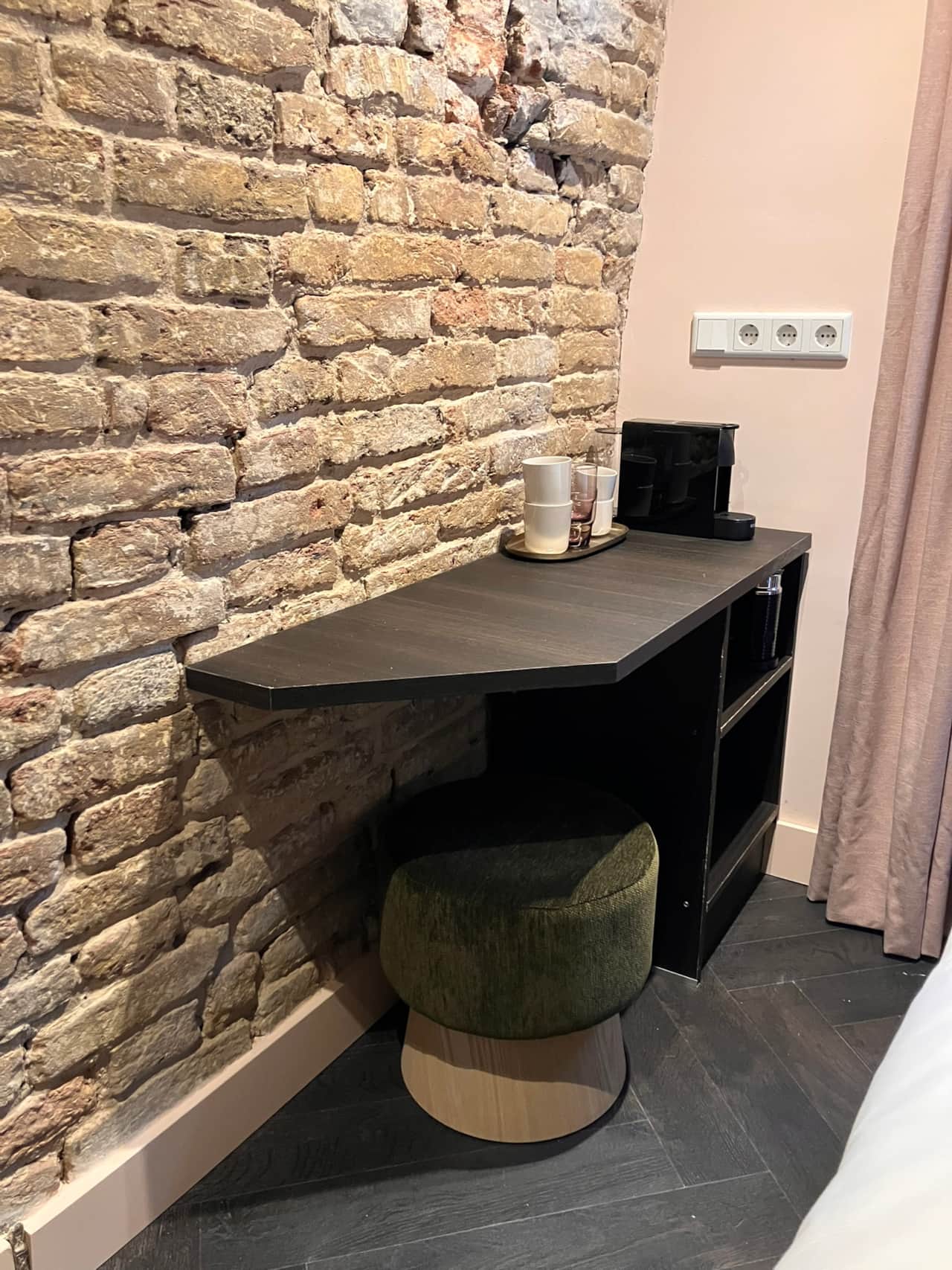 Robinah Suite desk against an exposed brick wall, with tea and coffee station