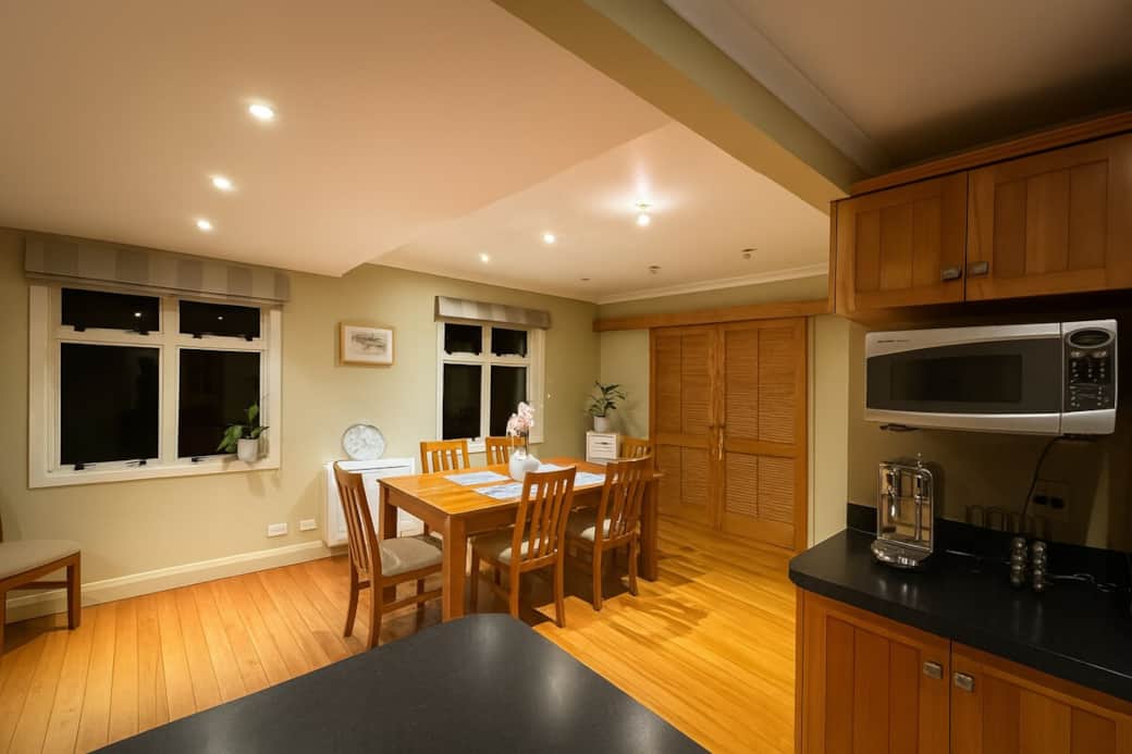 Enjoy the warmth of this spacious open-plan dining and kitchen space, The adjoining kitchen is fully equipped with a microwave, coffee machine, and generous bench space — ideal for preparing shared meals or quick snacks during your stay.