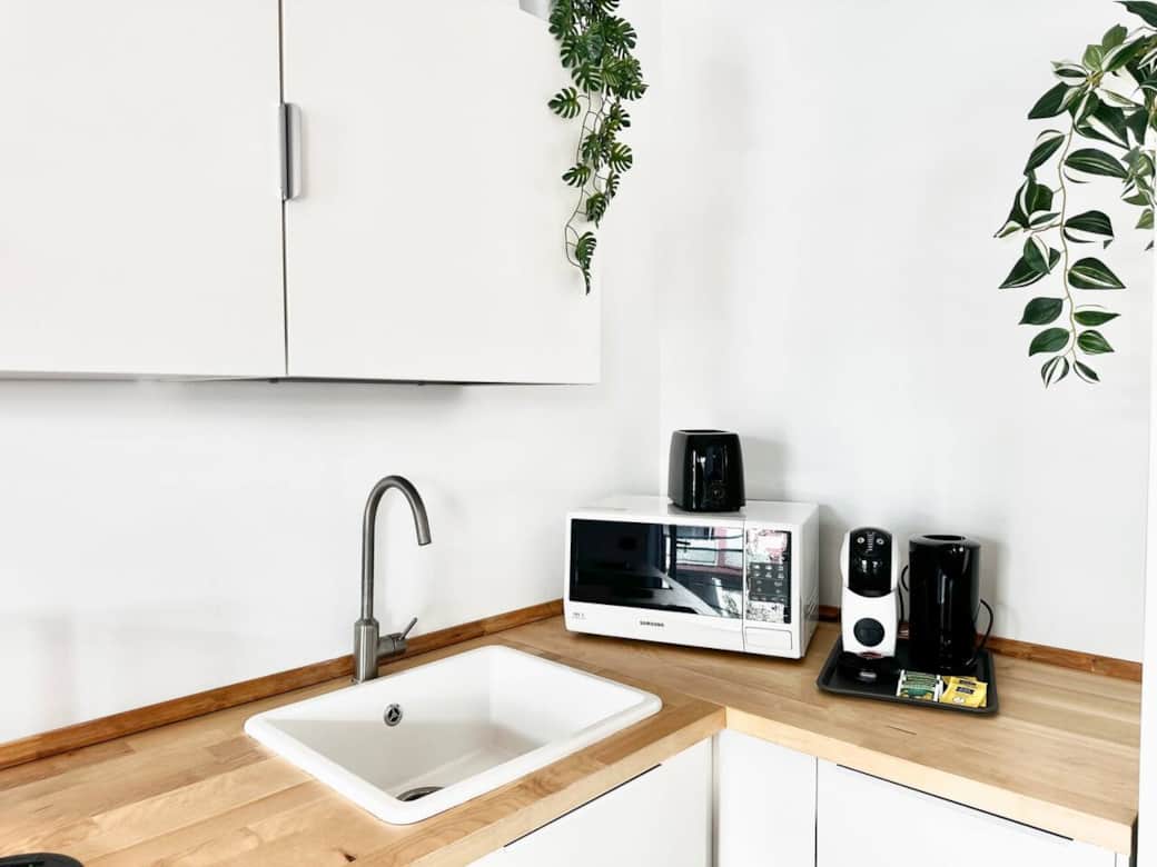 The open-plan kitchen is fully equipped with an oven, dishwasher, toaster, kettle, and coffee machine, making it perfect for socialising.