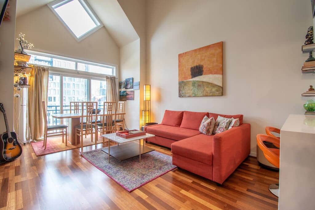 Spacious living room with sleeper sofa, flat screen smart TV, fireplace and dining table.