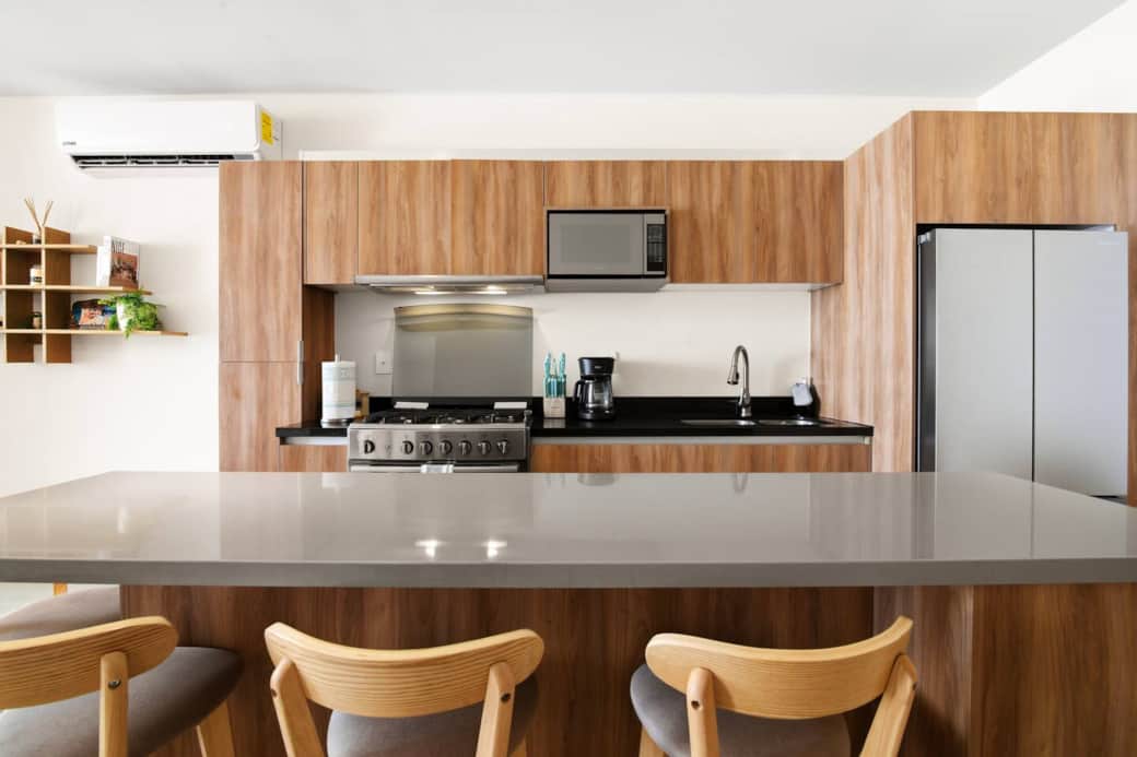 Fully equipped kitchen with all the amenities needed to prepare meals, including a stove and oven, microwave, blender, toaster, coffee machine, filtered drinking water and ice, plus a kitchen island with seating for four. Fully equipped kitchen with all the amenities needed to prepare meals, including a stove and oven, microwave, blender, toaster, coffee machine, filtered drinking water and ice, plus a kitchen island with seating for four.