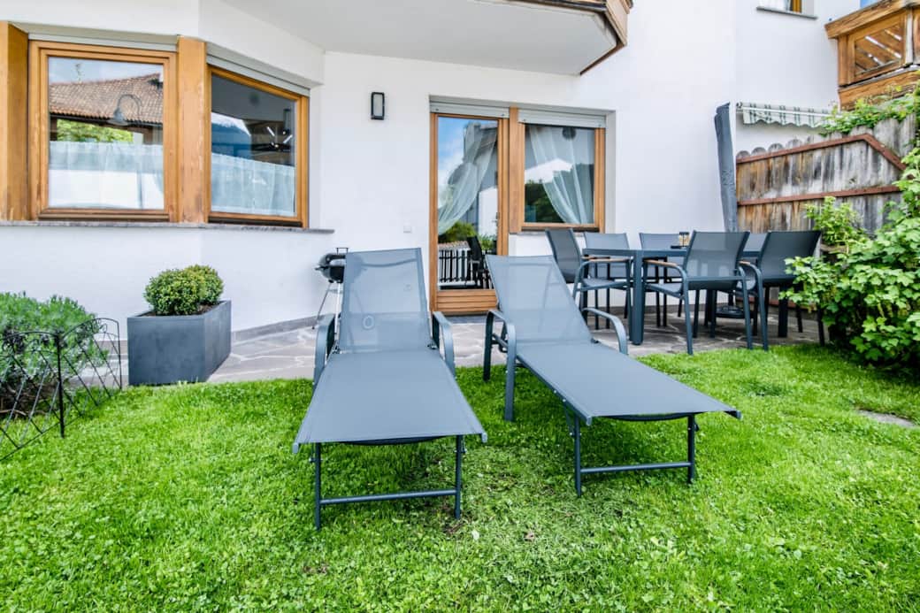 Private garden with sunbed, umbrella & dining space.