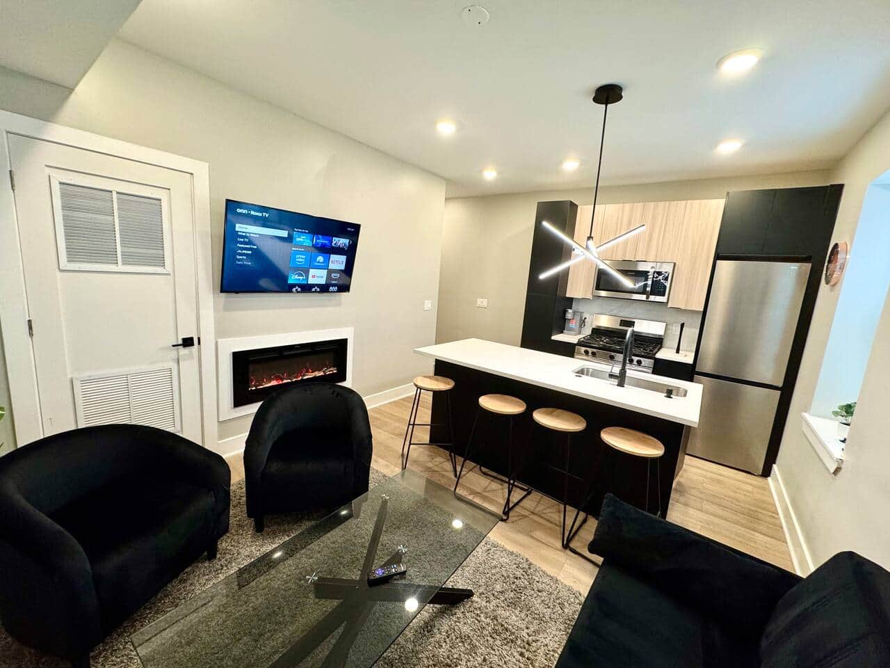 Modern living room, which is furnished with a futon sofa bed, fire place ,and a large flat-screen TV.